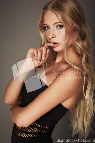 Image of Face, beauty and portrait of a seductive woman in studio with makeup, cosmetics and long hair. Headshot of female aesthetic model with natural glow, luxury skincare and sexy pose on a grey background