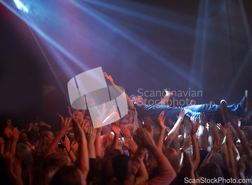 Image of Crowd surfing, lighting and people at rock concert or music festival, neon lights and energy at live event. Dance, fun and group of excited fans in arena at rock show performance, audience stage dive