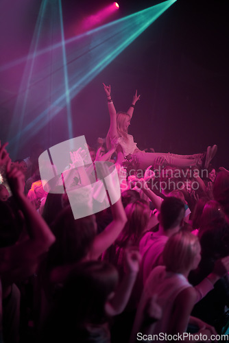 Image of Crowd surf, neon and people at music festival with neon pink lighting and energy at live concert event. Dance, fun and group of excited gen z fans in arena at rock band performance or audience party.