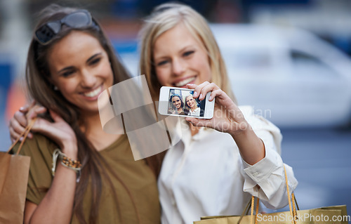Image of Shopping hug, selfie and happy customer, friends or women with memory picture of Black Friday spree, sales or product purchase. Social media, city fashion or stylish female people smile for shop deal