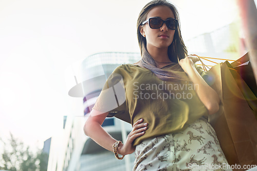 Image of Shopping bag, urban portrait and confident woman with fashion clothes present, retail choice or stylish store product. Fashionable, pride and chic female customer with glasses, sales spree and wealth