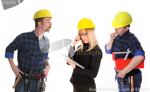 Image of angry businesswoman and construction workers 