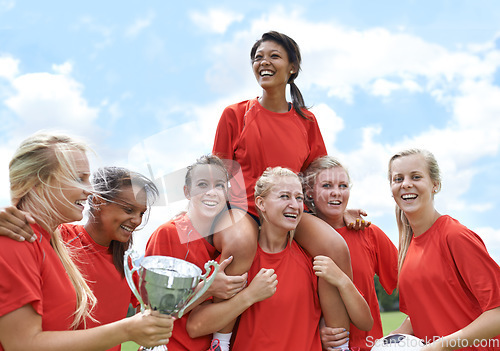 Image of Trophy, winner and girl soccer team celebrating victory, achievement and match success on field. Football, prize and female teenage sports group lifting champion for celebration, competition or goal