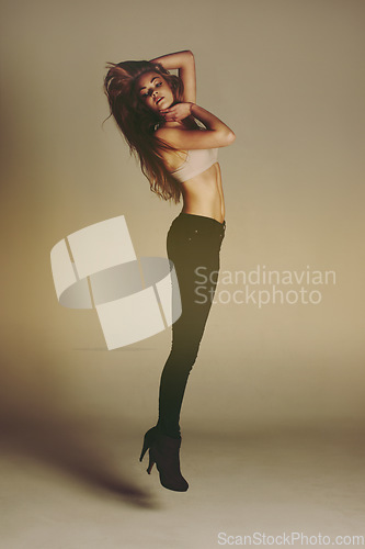 Image of Fashion, jump and woman in heels with style and freedom in a studio. Isolated, brown background and jumping of a young female person with beauty and body confidence with modern youth and carefree