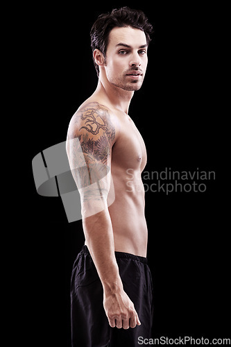 Image of Portrait, man and bare bodybuilder on black background, dark studio and muscular abdomen tattoo. Sexy, serious and strong male model, sports athlete and fitness power for exercise, training or muscle