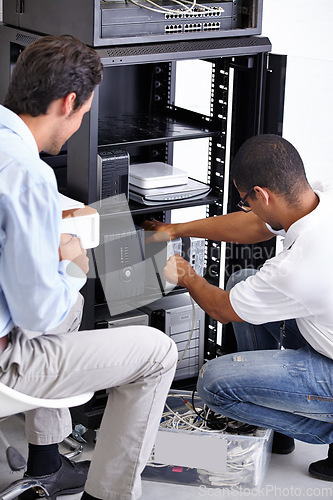 Image of Server room, man or electrician fixing electronics for hardware maintenance or working on glitch in office. IT support or worker with a technician or electrical engineer for information technology