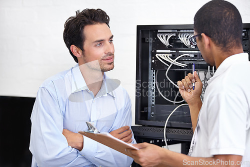 Image of Server room, man or technician speaking of software maintenance after glitch in business office. Network, tech support or worker with electrician or electrical engineer for information technology
