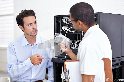 Image of Server room, it support and wires with an engineer talking to a business man about hardware or cable replacement. Network, database and spare parts with a technician explaining information technology