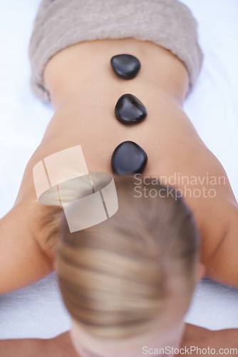 Image of Woman getting hot stone back massage at spa, holistic treatment and stress relief, self care at luxury wellness resort. Physical therapy, bodycare with rocks for healing and zen with top view