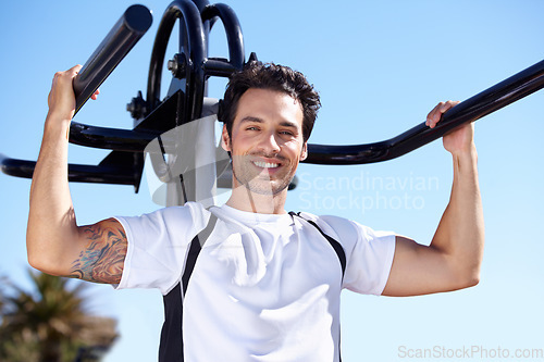 Image of Happy man, fitness and portrait with equipment at park gym for workout, exercise or training in nature. Fit, active and strong male exercising on outdoor machine for strength or weightlifting