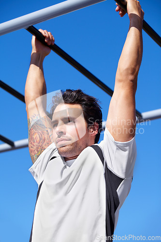 Image of Man, fitness and pull ups on monkey bars in park gym for weightlifting, exercise or workout in nature. Fit, active and strong male lifting body weight or hanging on iron bar for strength exercising