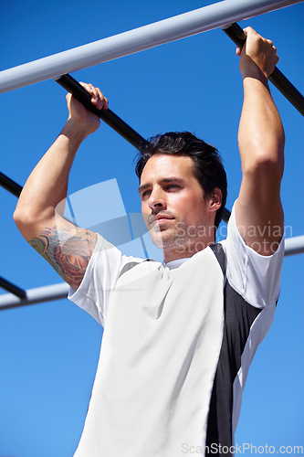 Image of Man, fitness and pull ups on monkey bars in nature, park or outdoor gym for weightlifting, exercise or workout. Fit, active and strong male lifting body weight or hanging on iron bar for exercising