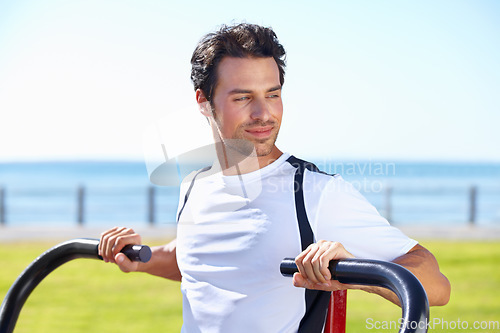 Image of Man, fitness and shoulder press at park for workout, exercise or training in nature by the beach gym. Fit, active or strong male exercising on outdoor machine for muscle, chest or healthy cardio