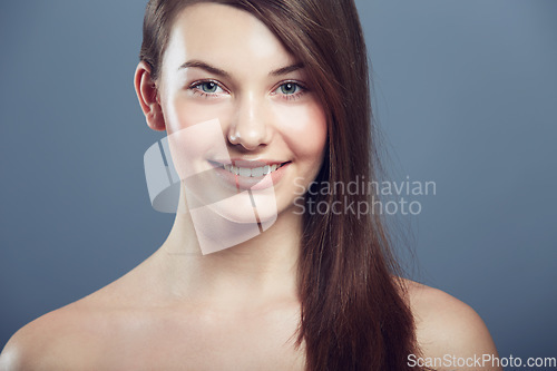 Image of Face, skin and beauty portrait of a woman in studio with natural makeup, smile and cosmetics. Happy aesthetic gen z female model on a grey background for glow, hair care and facial dermatology shine
