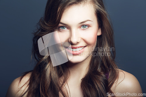 Image of Beauty, natural and portrait of happy woman in studio with makeup, facial and skincare routine. Health, smile and face of young female model with cosmetic or dermatology treatment by blue background.