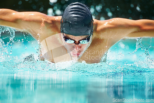 Image of Health, sports and training with man in swimming pool for competition, workout and energy. Strong, water splash and cardio with male swimmer and practice for athlete, championship and race at gala