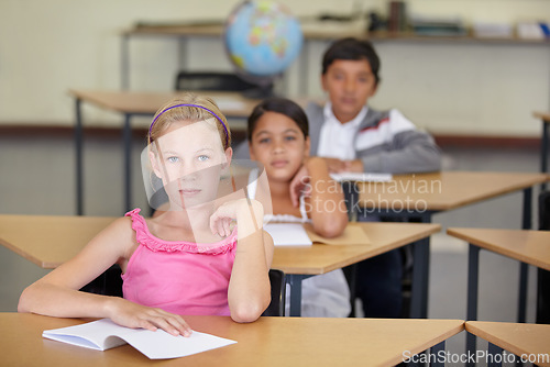 Image of Portrait, serious kids and student in classroom with book, ready to learn and study in class. Group of students, education and girl learning in primary school for knowledge, development or studying.