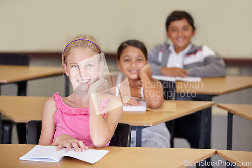 Image of Portrait, kids and smile of student in classroom with book, ready to learn and study in class. Group of students, education and girl learning in primary school for knowledge, development or studying.