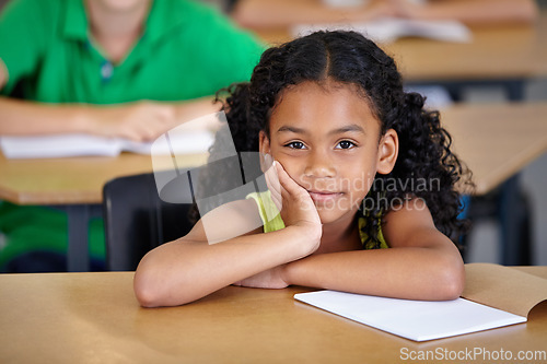 Image of Portrait, kid and bored student in classroom with book, ready to learn and study in class. Boredom, education and serious Indian girl learning in primary school for knowledge, development or studying