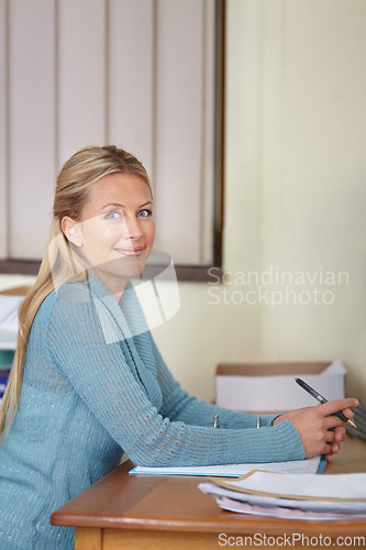 Image of Woman, portrait and teacher grading in school with paperwork on desk in class. Teaching, female educator and person from Canada ready to start marking paper for learning, education and knowledge.