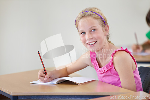 Image of Portrait, child and smile of student learning in classroom for knowledge, education or development. Happy, girl and learner writing in notebook, studying or taking notes in middle school in Canada.