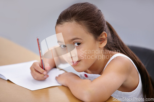 Image of Portrait, kid and education of student taking notes in classroom for knowledge and development. Serious, girl and learner writing in notebook, studying or learning in middle school class in Spain.