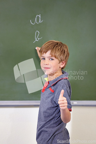 Image of Portrait, child and student with thumbs up on blackboard in classroom, elementary school and mockup. Chalkboard, education and kid with hand gesture for like emoji, agreement and learning to write.