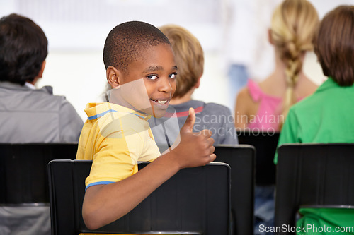 Image of Portrait, black child and thumbs up of student in classroom, elementary school or class. Smile, education and kid with hand gesture for like emoji, agreement and learning, success and approval sign.