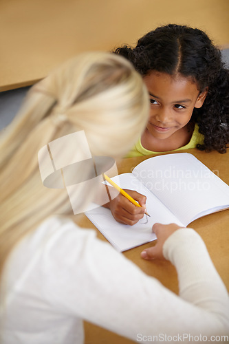 Image of Woman helping girl, education and writing in notebook with pencil, teaching and learning for growth and development. People in classroom to learn, academic study with teacher and student at school