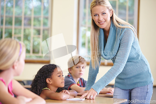 Image of Portrait, woman and smile of teacher in class helping students in classroom. Teaching, female educator and happy person with children learning in primary school for education, studying or knowledge.