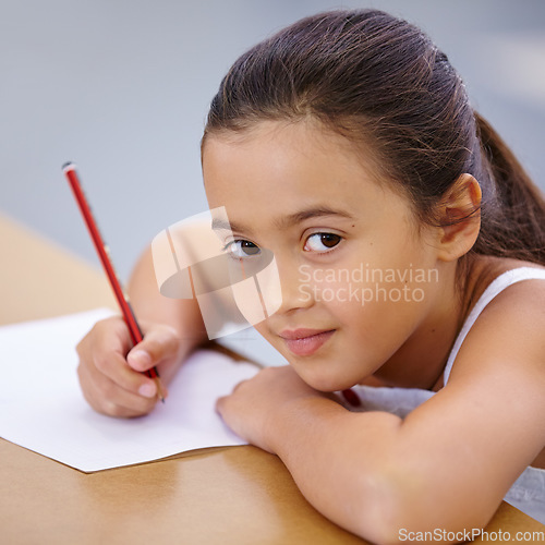 Image of Child, portrait and education of student taking notes in classroom for knowledge and development. Serious, girl and learner writing on paper, studying or learning in middle school class in Spain.