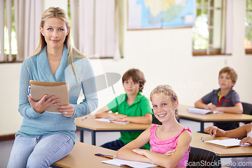 Image of Portrait, teacher and woman with children in classroom, smile and holding folder. Happiness, female educator and students ready for learning, knowledge or studying in elementary school for education.