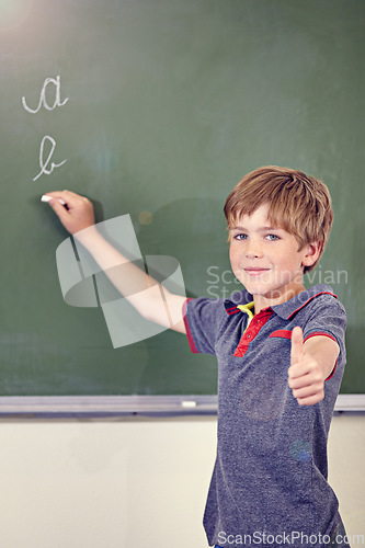 Image of Portrait, child writing and thumbs up on blackboard in classroom, elementary school and mockup. Chalkboard, education student and kid with hand gesture for like emoji, agreement and learning to write