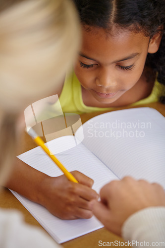 Image of Closeup of teacher helping student, education and writing in notebook, teaching and learning for development. People in classroom to learn, academic study and young girl, woman in lesson at school