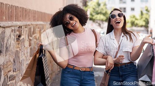 Image of Friends, women with shopping bag and happiness in city, retail customer and fashion with shopper at outdoor mall. Excited female people in urban street, sale and discount with promotion at boutique