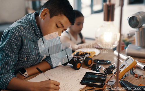 Image of Learning, writing in notebook and child with robotics homework, homeschool and science for tech project. Taking notes, car robot and boy kid with knowledge, education and studying in house alone.