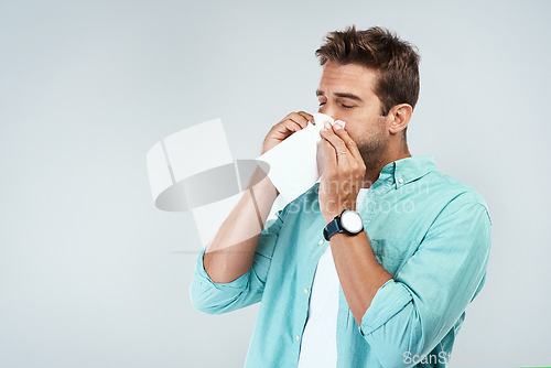 Image of Allergy, sick and man blowing nose in tissue with flu, illness and virus on studio background. Health mockup, wellness and face of male person with handkerchief for hayfever sinus, cold and sneeze