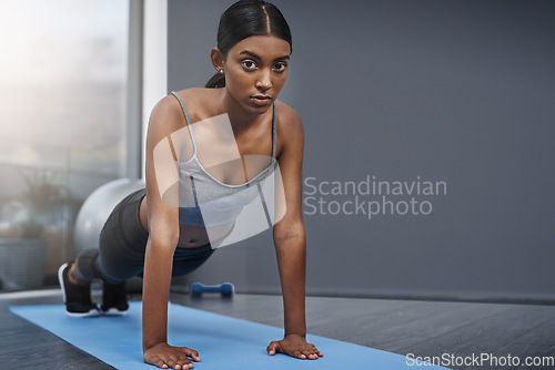 Image of Push ups, serious and portrait of woman fitness in the gym training, exercise or workout for health and wellness. Yoga, sports and healthy female person stretching for morning sport performance