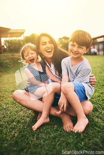 Image of Mother, happy kids or hug playing on grass for fun bonding in summer outside a house in nature. Funny mom hugging playful children on garden playground outdoors with happiness of family together