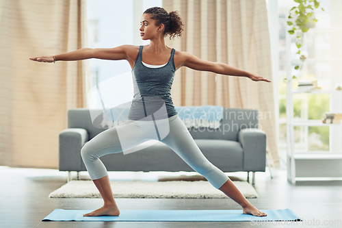 Image of Yoga, pilates and woman stretching in home for wellness, workout and fitness in living room. Healthy body, warrior pose and female person doing exercise for balance, flexibility and wellbeing on mat