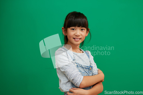 Image of Happy, arms crossed and portrait of Asian girl in studio for smile, fashion and youth. Happiness, casual and cute with young child isolated on green background for mockup student and confidence