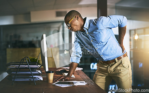 Image of Black man with back pain, night business and stress with injury, health problem and burnout from overtime. Male professional work late, backache and medical emergency with bad posture and overworked