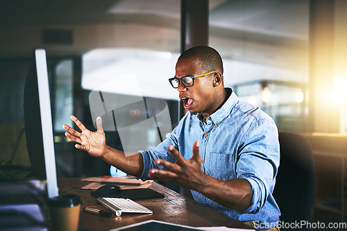 Image of Black man in office, night and angry with computer glitch, stress with software problem. Male professional with anger, connection issue and working late, frustrated with 404 and business crisis