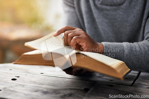 Image of Hands, story and a man reading the bible at a table outdoor in the park for faith or belief in god. Book, religion and spiritual with a male christian sitting in the garden for learning or worship