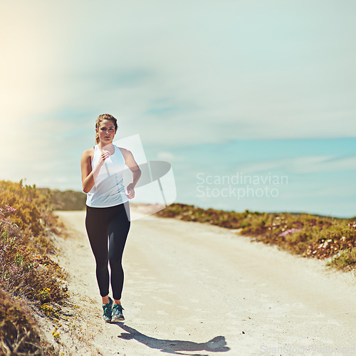 Image of Woman running on road, fitness outdoor with cardio and training for race with athlete, sports and mockup space. Female runner in nature, blue sky and run for exercise with healthy and active person