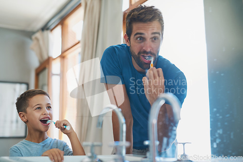 Image of Happy, brushing teeth and father with son in mirror of bathroom for morning routine, bonding and dental. Oral hygiene, cleaning and smile with man and child in family home for self care and wellness