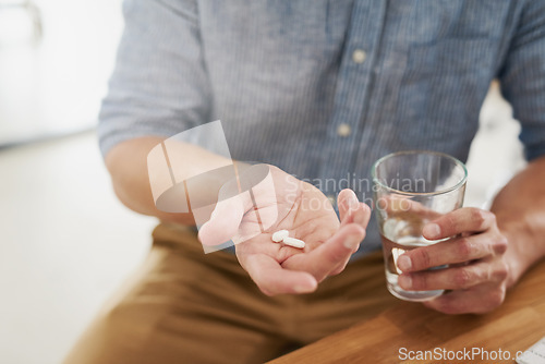 Image of Medicine, pills and water with hands of man for medical, vitamins and supplements. Healthcare, prescription and pharmacy with closeup of male patient at home for drugs, allergy and mental health