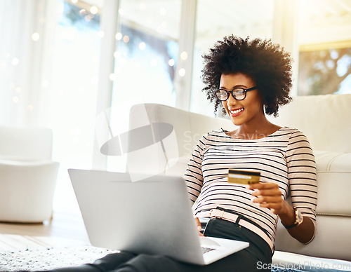 Image of Young woman, laptop and credit card in living room doing online shopping sitting on ground. Home, happiness and computer of African female person on a internet ecommerce app reading online deal