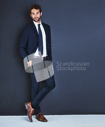 Image of Portrait, fashion and a mockup with a business man in studio on a blue background for contemporary corporate style. Success, professional and a confident male employee in a suit for executive power