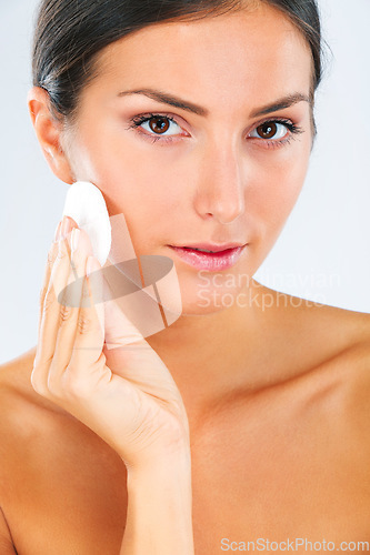 Image of Skincare, portrait and female model with a cotton pad in studio for a beauty, natural and face routine. Health, wellness and woman with health, wellness or cosmetic facial product by white background
